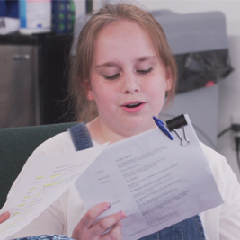 A student reads from a script.